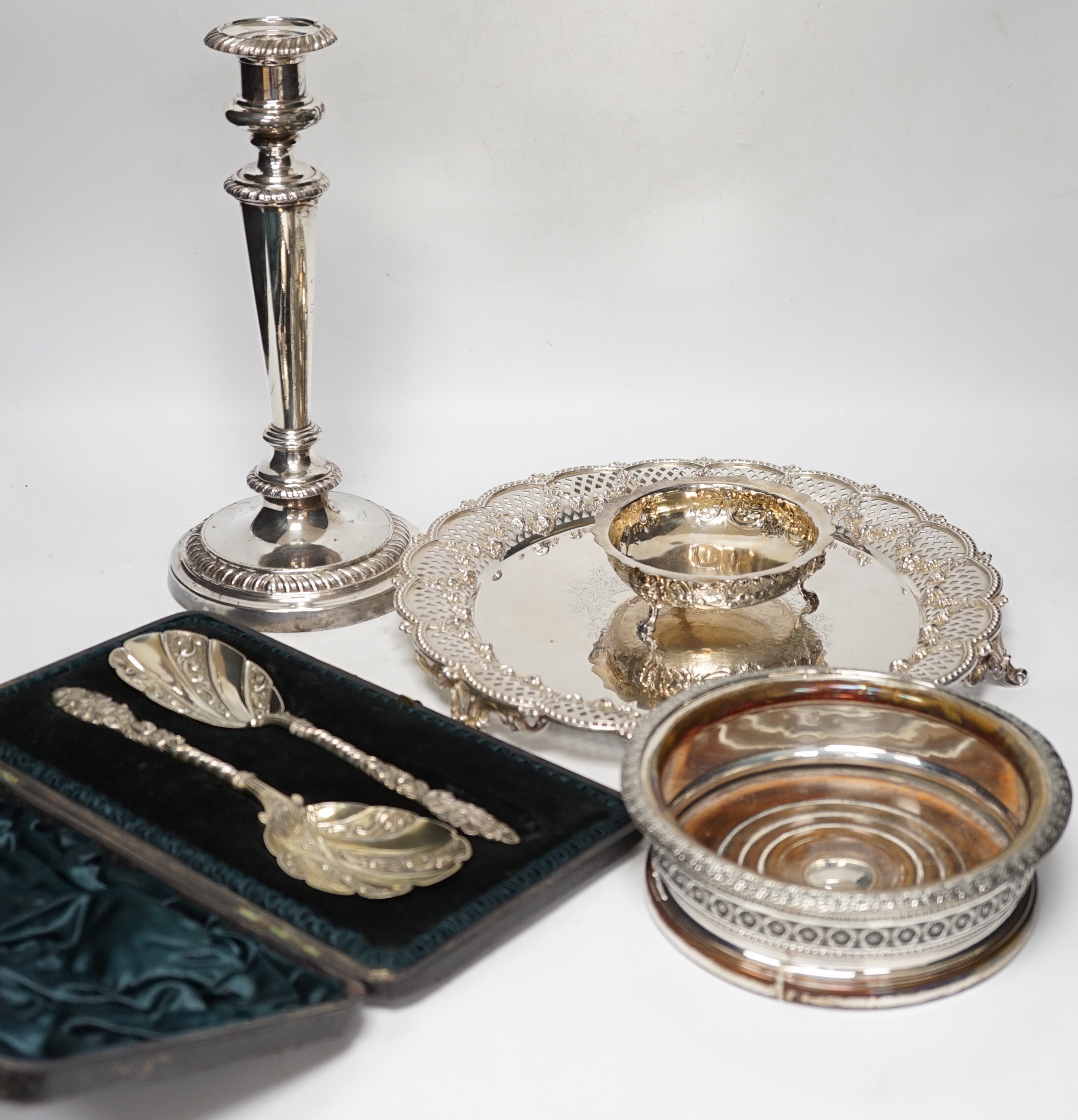 Plated wares: a pair of wine coasters, two ornate basket-edged dishes, a sugar bowl, three candlesticks, three candleholders, a teapot, ice bucket cased serving spoons and a metal mounted glass decanter.